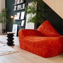 Interior of a room with an orange chaise.