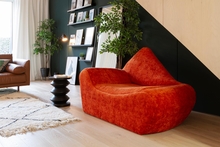 Interior of a room with an orange chaise.